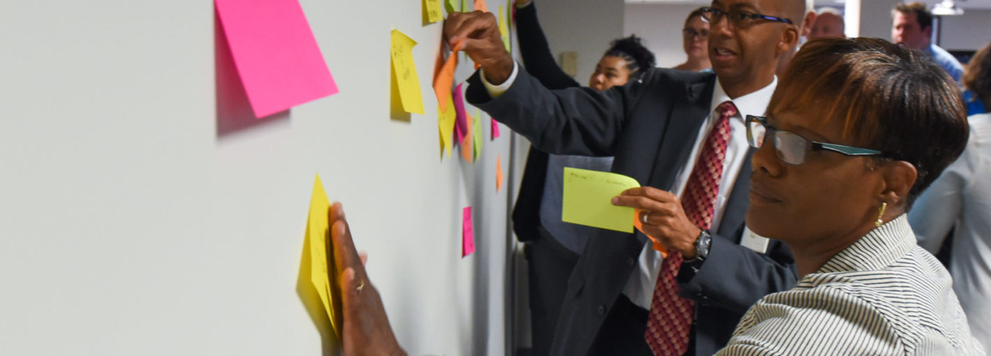 Business people at whiteboard with Post-it notes