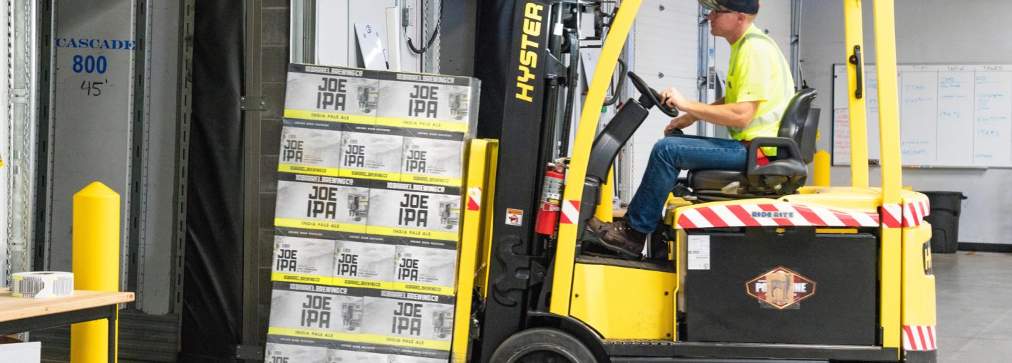 Forklift operating lifting a pallet of beer